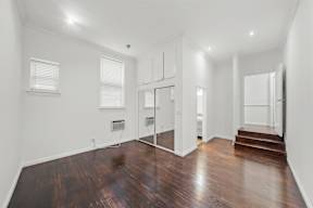 Beautiful bedroom in 6128 Wilshire apartment home with wood flooring, high ceilings, oversized closet, and private bathroom