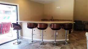 A bar area with four stools and a counter.