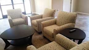 A living room with a sofa, armchair, and coffee table.