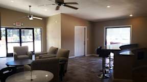 A living room with a ceiling fan and a table with chairs.