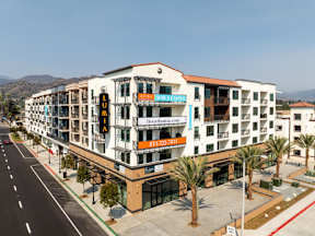 A multi-story building with a white facade and a red roof.