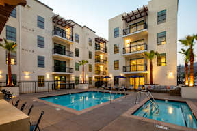 A large swimming pool in front of apartment buildings.