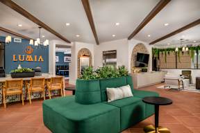 A green couch sits in the middle of a room with wooden floors and a white ceiling.