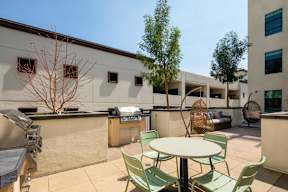 A patio with a table and chairs is surrounded by buildings.
