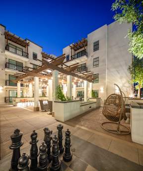 A chess set is set up on a patio.