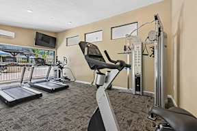 Fitness center at Oro Apartments with plenty of machines and bright lighting