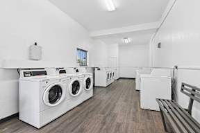 Community laundry center at Oro Apartment homes with wood-style plank flooring and plenty of machines for convenience