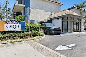 Entrance to Oro Apartments with monument sign and leasing office