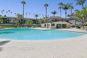 Pool Area at Oro apartment homes with chaise lounges and beautiful treelined views for ultimate relaxation