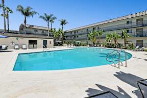 Pool Area at Oro apartment homes with chaise lounges and beautiful treelined views for ultimate relaxation