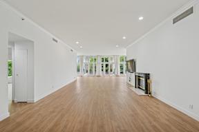 A long, empty room with wooden floors and white walls.