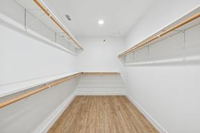 A long hallway with white walls and wood floors.