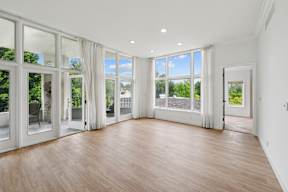 A large empty room with wooden floors and white walls.