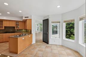 A kitchen with wooden cabinets and a black refrigerator.