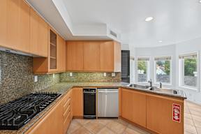 A kitchen with wooden cabinets and a black stove top.