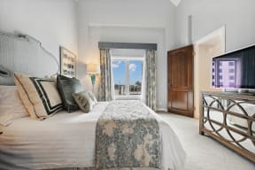 a bedroom with a bed and a tv and a window