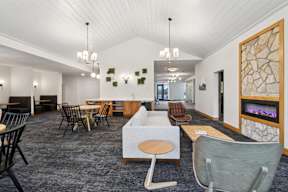 A modern lounge area with a variety of seating options and a fireplace.
