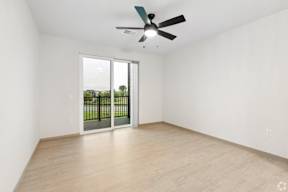 A room with a ceiling fan and sliding glass doors to the patio located at Deforest Yards apartments in DeForest, WI