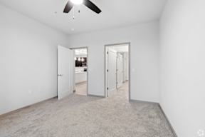 A room with a ceiling fan and carpeted floor located at Deforest Yards apartments in DeForest, WI