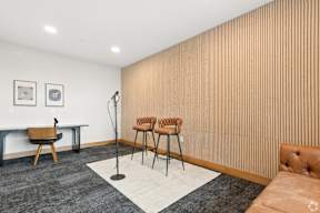 A podcast room with a wooden wall and a brown chair located at Deforest Yards apartments in DeForest, WI