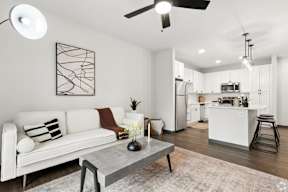 A modern living room with a white couch and a grey coffee table located at Deforest Yards apartments in DeForest, WI