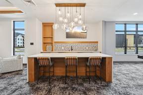 A modern kitchen with a long table and striped chairs.