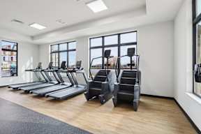 A fitness center with treadmills and exercise machines located at Deforest Yards apartments in DeForest, WI