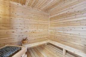 A wooden sauna with benches and a bench warmer.