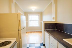 A kitchen with a stove, refrigerator, and sink.