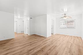 A room with wooden flooring and a ceiling fan.
