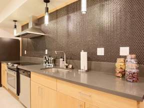 A kitchen with a black wall and wooden cabinets.