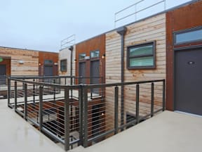 A wooden building with a metal railing in front.