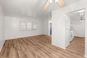 A room with a wood floor and a ceiling fan.