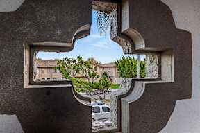 A view of a street through a cut-out window.