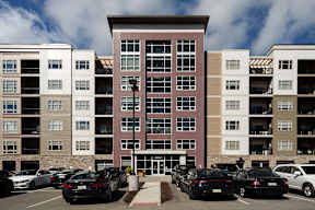 A parking lot with cars in front of apartment buildings.at Cosmopolitan Apartments, Pittsburgh Pennsylvania