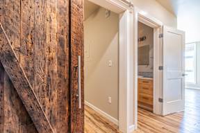 A white door is open to a room with a wooden staircase on the left.