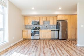 A kitchen with wooden floors and stainless steel appliances.