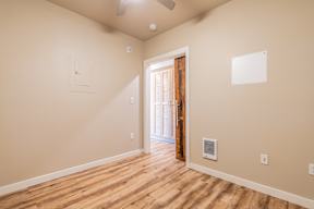 A room with wooden flooring and a ceiling fan.