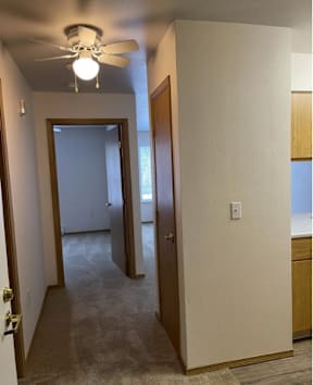 A room with a ceiling fan and a light fixture.