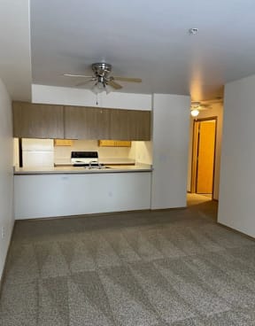 A kitchen area with a fan on the ceiling.