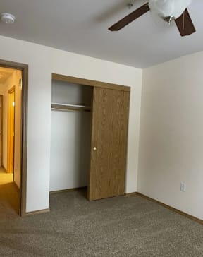 A room with a ceiling fan and a wooden door.