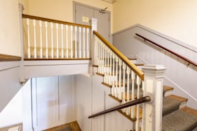 A staircase with a white balustrade and a wooden handrail.