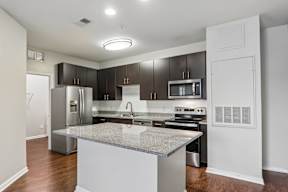 A kitchen with a granite countertop and stainless steel appliances.