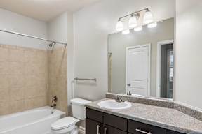 A bathroom with a sink, toilet, and bathtub.