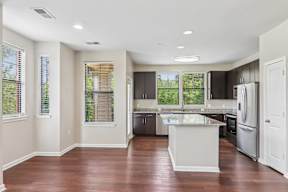 A kitchen with a white island and stainless steel appliances.