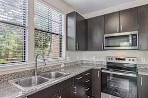 A kitchen with a stainless steel oven and microwave.