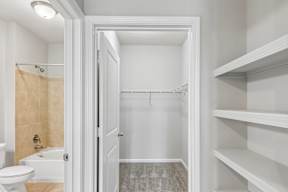 A white bathroom with a toilet, sink, and shower.