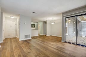 an open living room and dining room with a sliding glass door at Veridian at Sandy Springs in Georgia