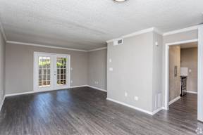 A room with a window and a door leading outside.