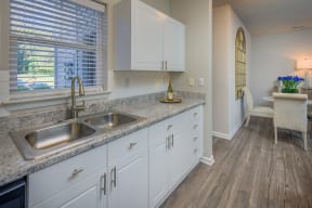 white kitchen cabinets and natural light filled kitchen with hardwood floors at Stone Ridge apartments Charlotte